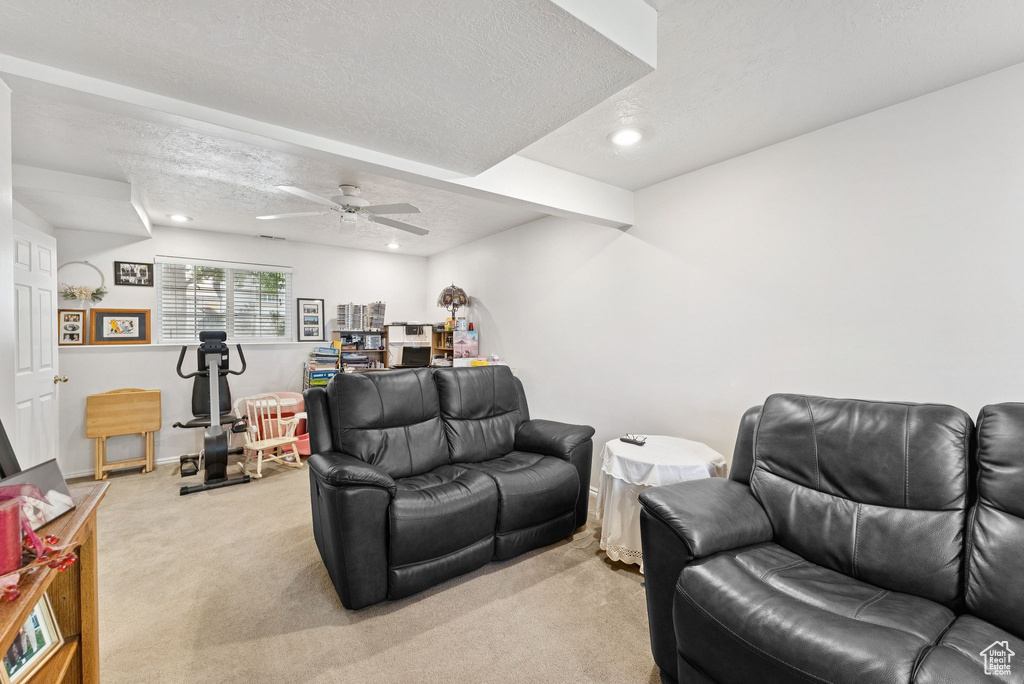 Living area featuring light carpet, a ceiling fan, recessed lighting, and a textured ceiling
