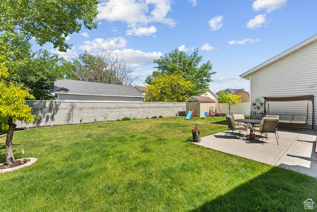 Fenced backyard with a playground and a patio