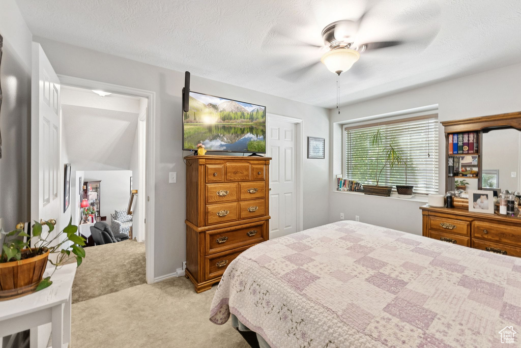 Bedroom featuring light carpet and ceiling fan