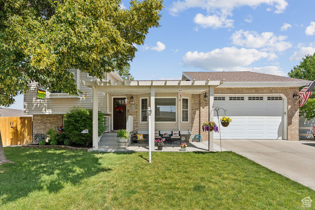 View of front of property featuring brick siding, driveway, and an attached garage