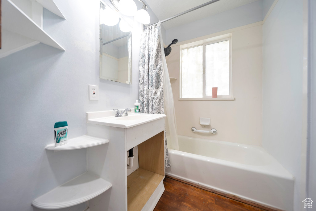 Full bathroom with shower / tub combo, vanity, and wood finished floors