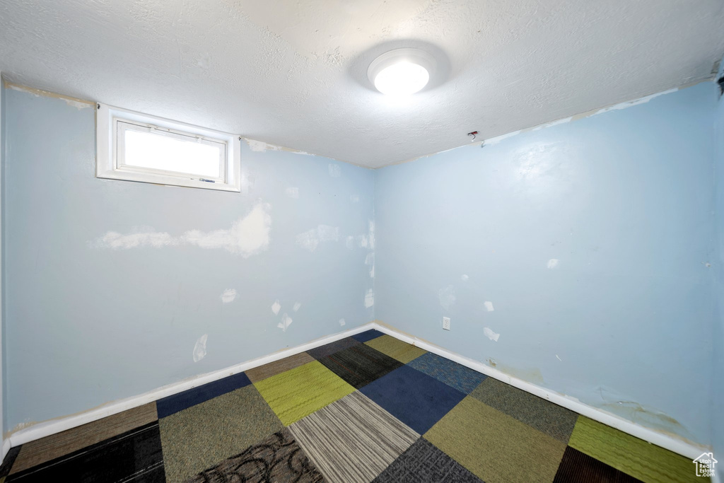 Below grade area featuring baseboards and a textured ceiling