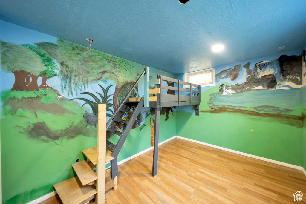 Bedroom with wood finished floors and a textured ceiling