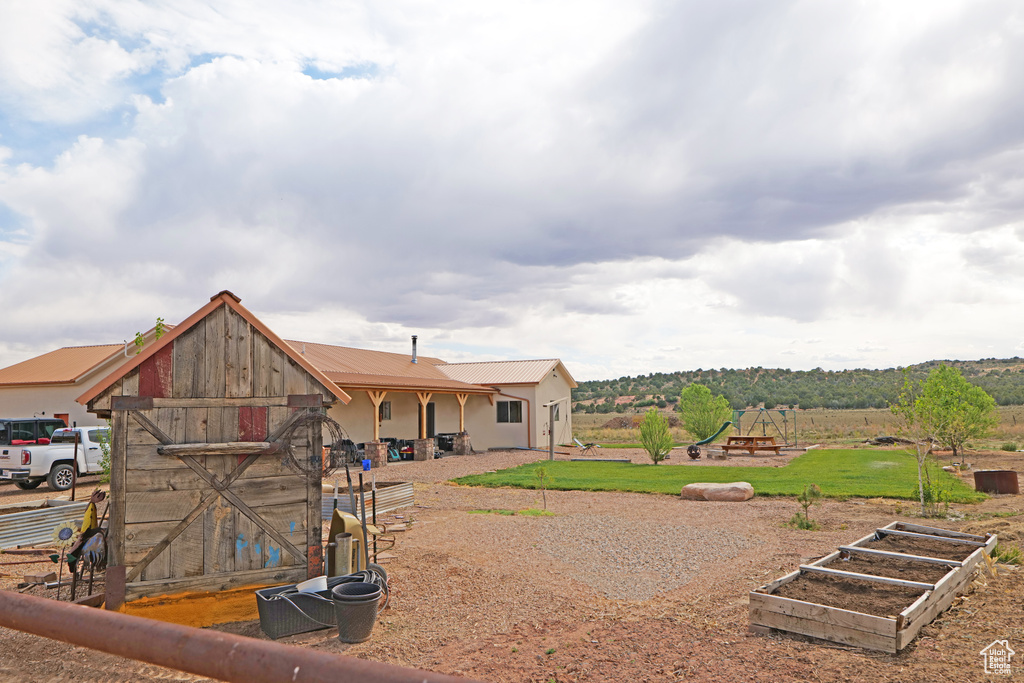Back of property with a garden and a metal roof