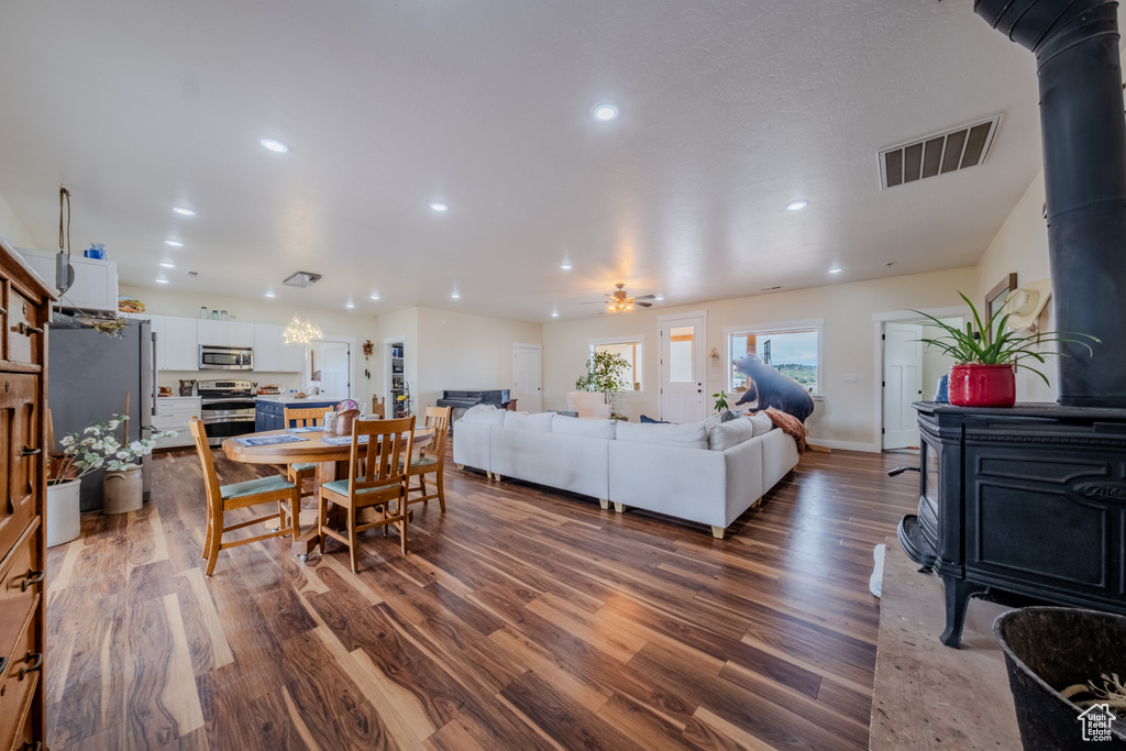Living area featuring a wood stove, dark wood-type flooring, recessed lighting, and a ceiling fan