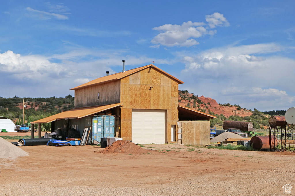 View of outbuilding featuring dirt driveway and a mountain view
