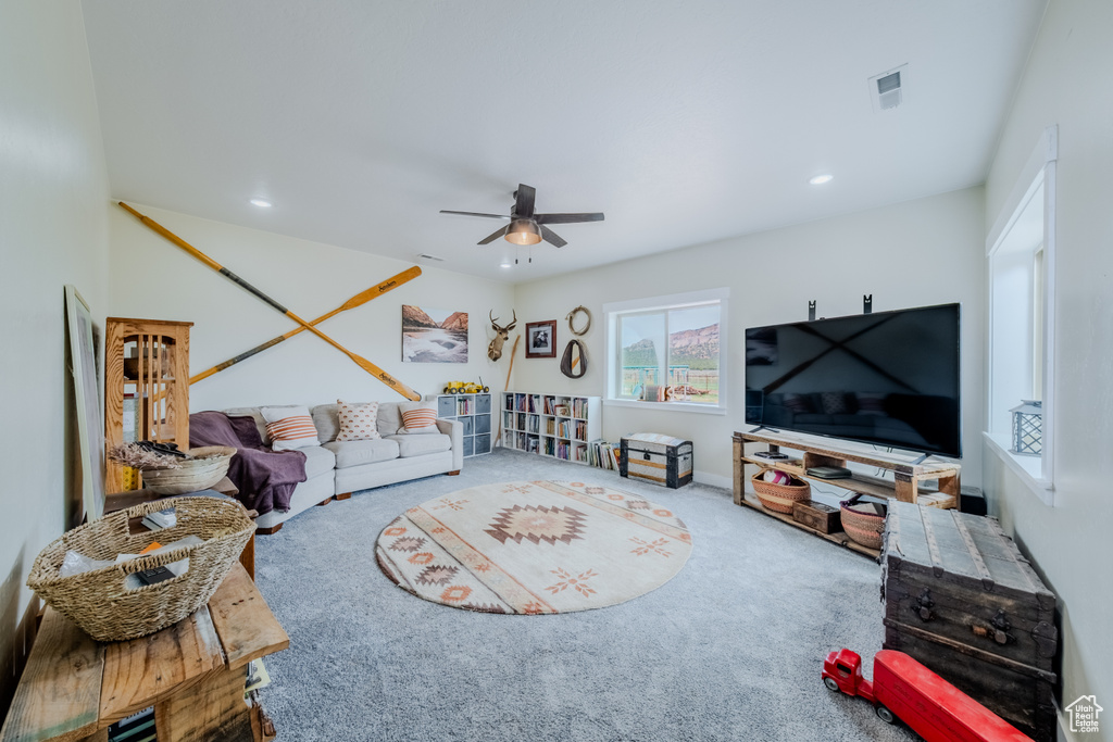 Carpeted living area featuring a ceiling fan and recessed lighting