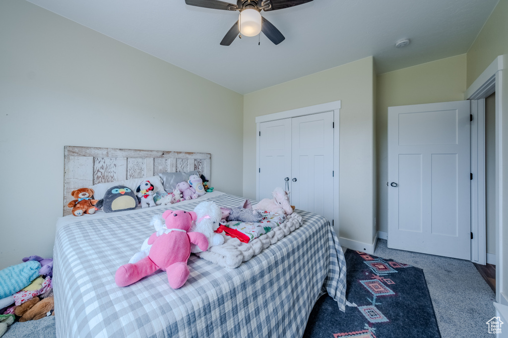 Bedroom with carpet, a closet, and a ceiling fan