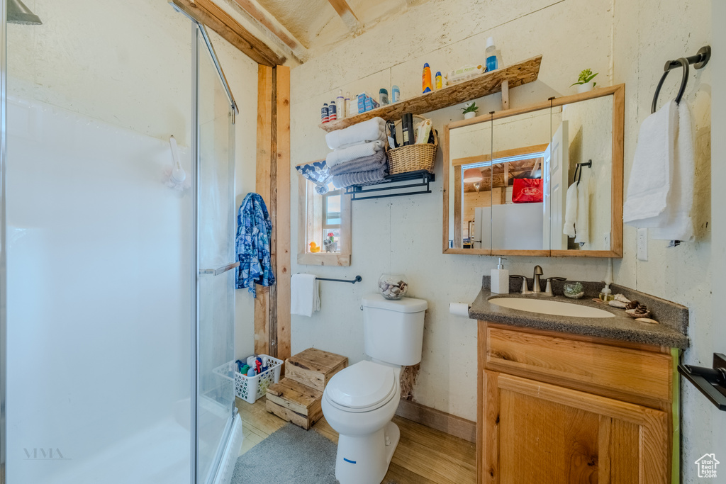 Bathroom with a shower stall, vanity, and wood finished floors