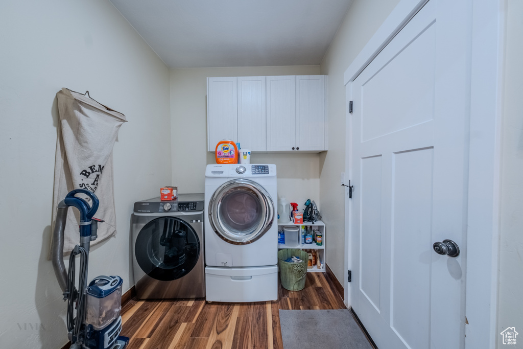 Washroom featuring cabinet space, independent washer and dryer, and dark wood-style floors