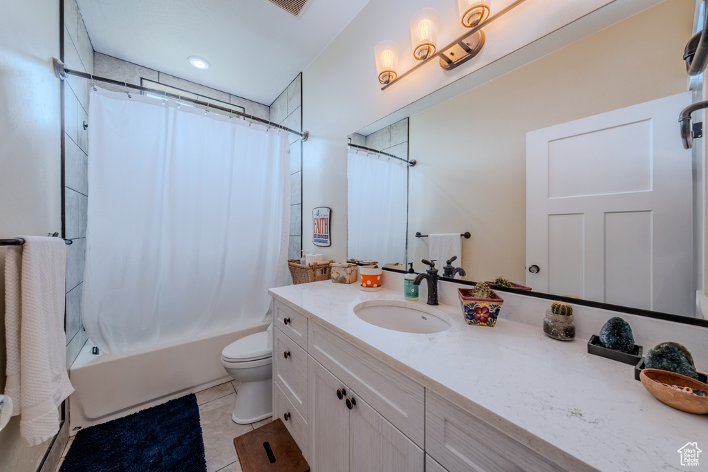 Bathroom featuring vanity, shower / bathtub combination with curtain, and tile patterned floors