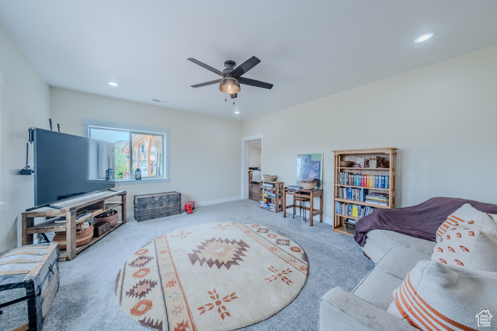 Carpeted living room with recessed lighting and ceiling fan