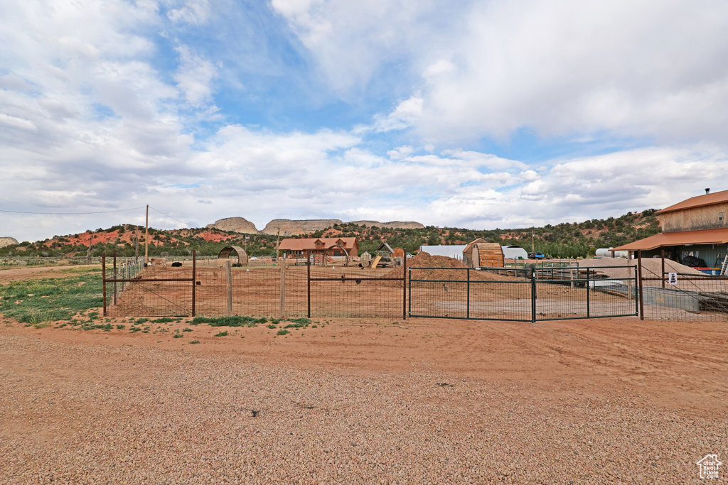 View of yard with a mountain view, a gate, and a rural view