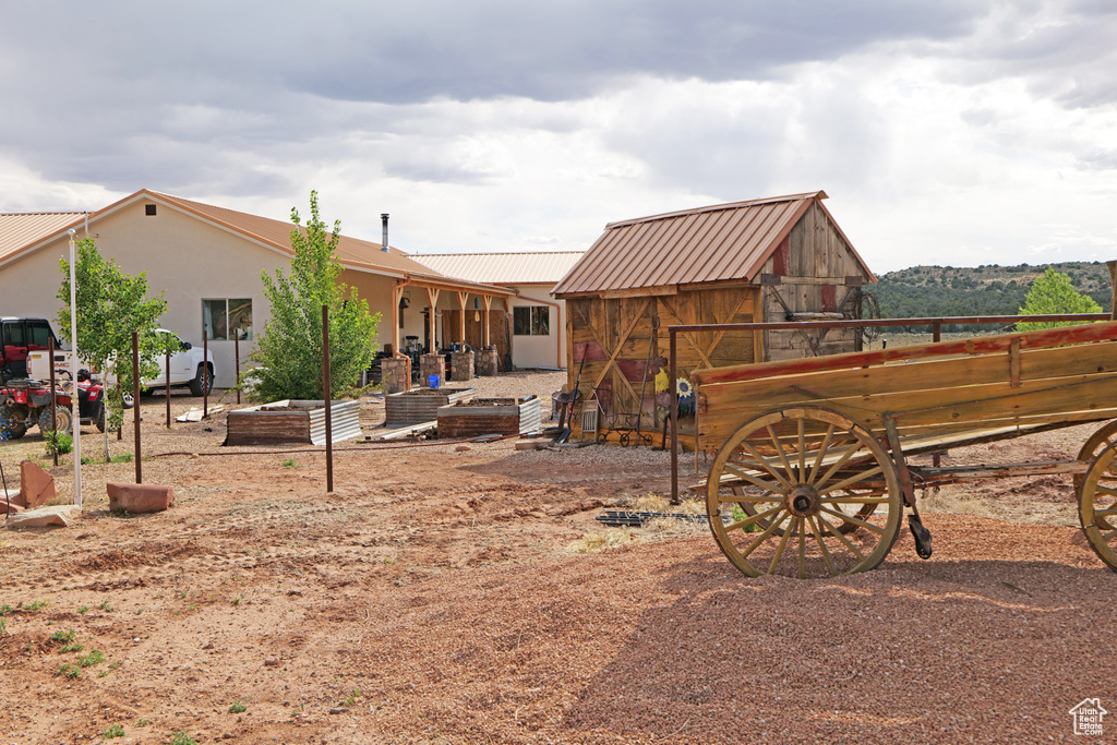 Rear view of property featuring a metal roof and an outdoor structure