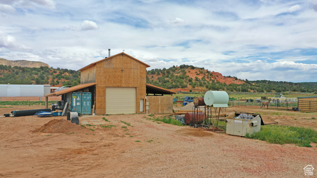 View of outdoor structure featuring dirt driveway and a mountain view