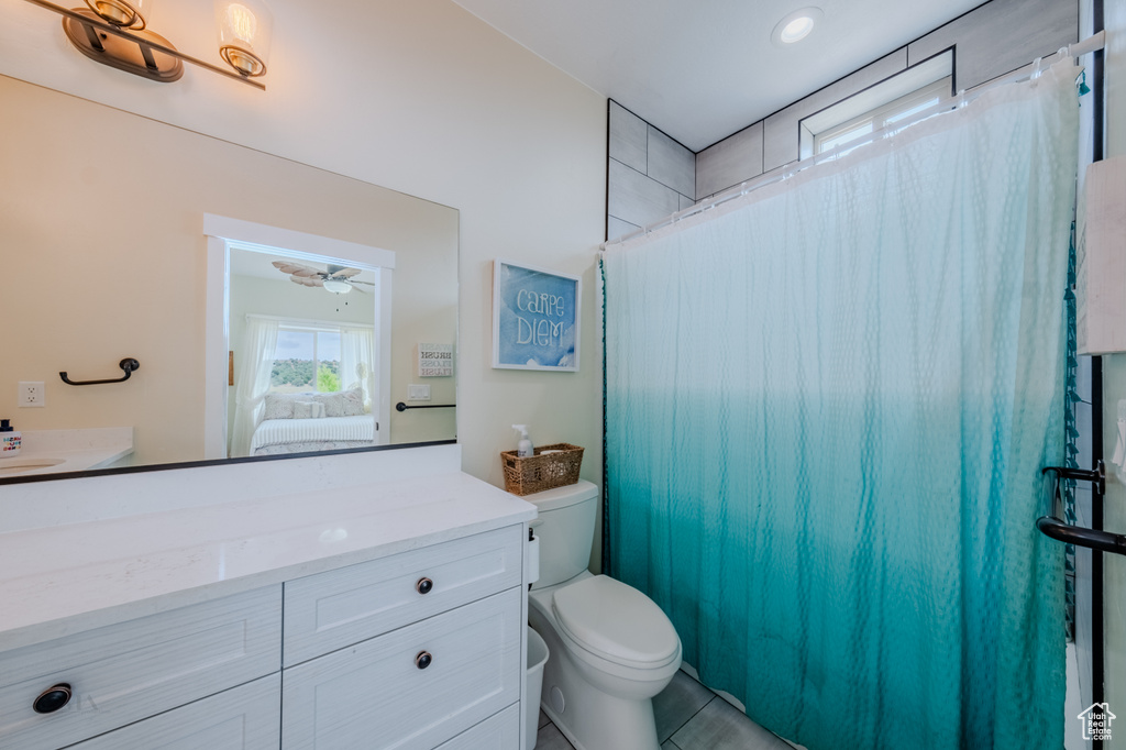 Ensuite bathroom with vanity, a ceiling fan, and curtained shower