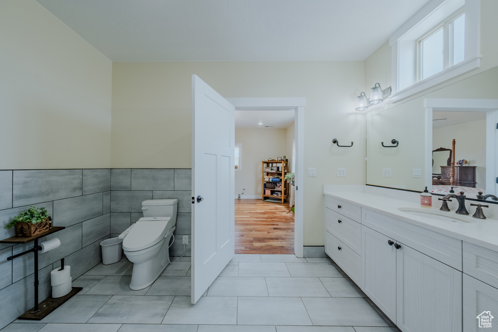 Bathroom with vanity, tile patterned flooring, and tile walls