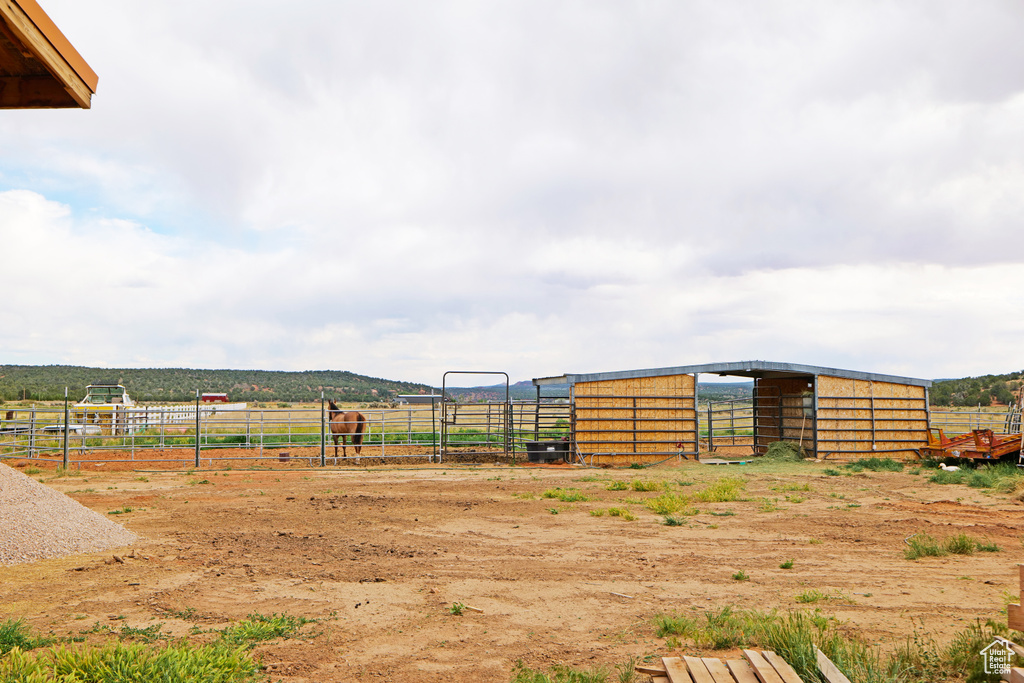 View of yard featuring a rural view, an outbuilding, and an exterior structure