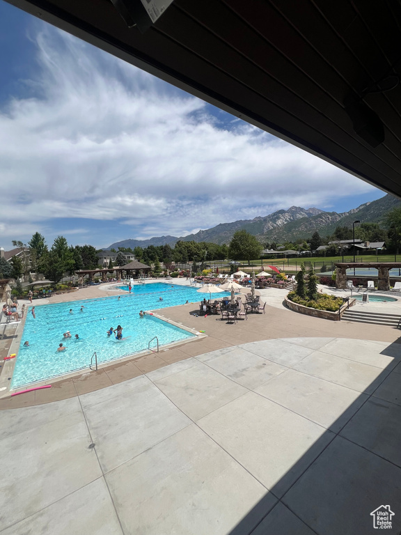Community pool with a mountain view, a jacuzzi, and a patio