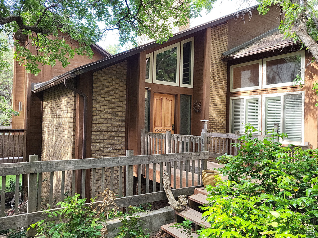 View of front of home featuring brick siding and a deck