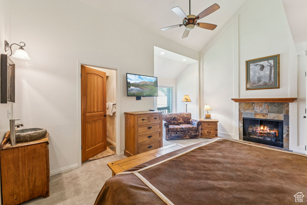 Carpeted bedroom with vaulted ceiling, a tiled fireplace, recessed lighting, and a ceiling fan