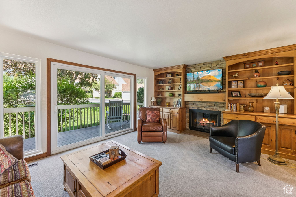 Living area with light carpet, a fireplace, and built in shelves