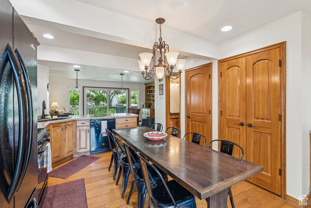 Dining area with light wood-type flooring, recessed lighting, and a chandelier