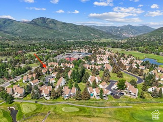 View of property location with a mountainous background, a golf club, and nearby suburban area