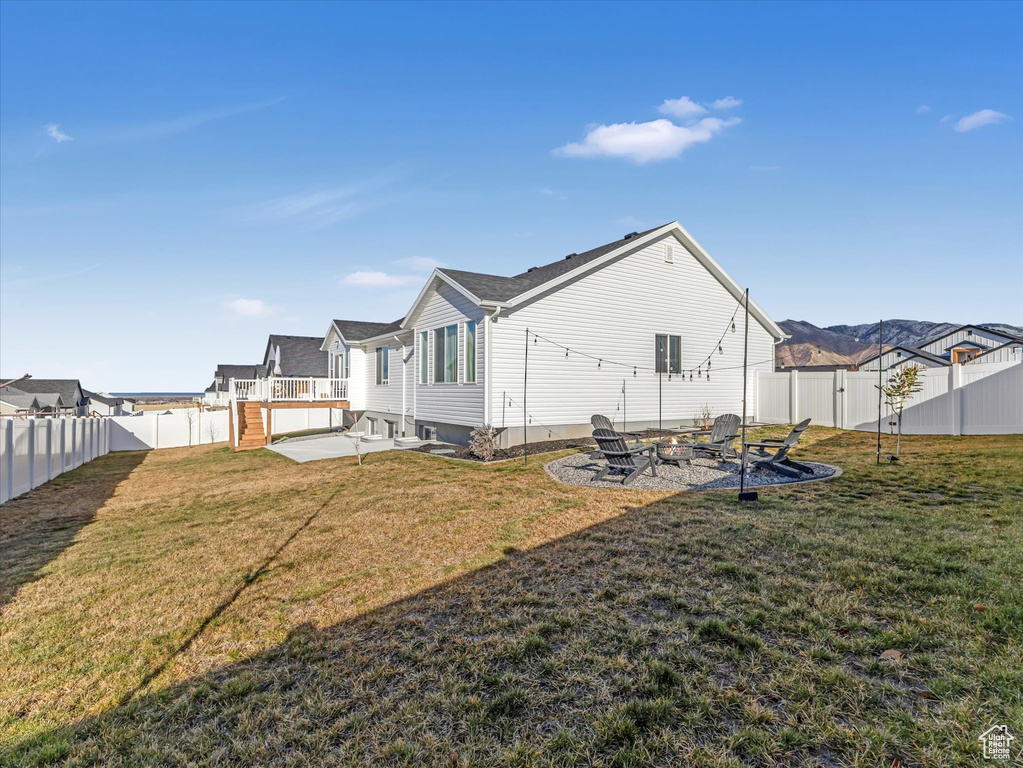 Back of house with an outdoor fire pit and a patio