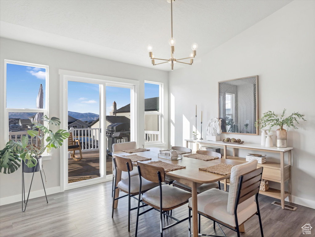 Dining area featuring a chandelier, wood finished floors, and baseboards