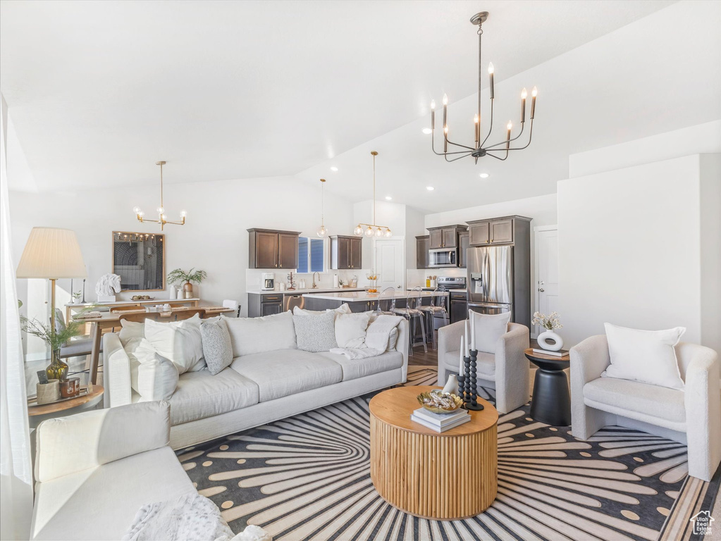 Living room featuring a chandelier, vaulted ceiling, and recessed lighting