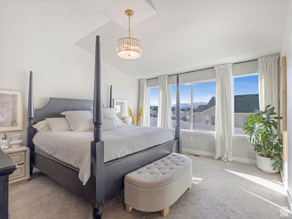 Bedroom featuring light carpet, baseboards, a chandelier, and vaulted ceiling