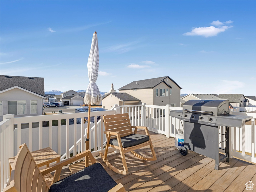 Wooden terrace featuring a residential view and area for grilling