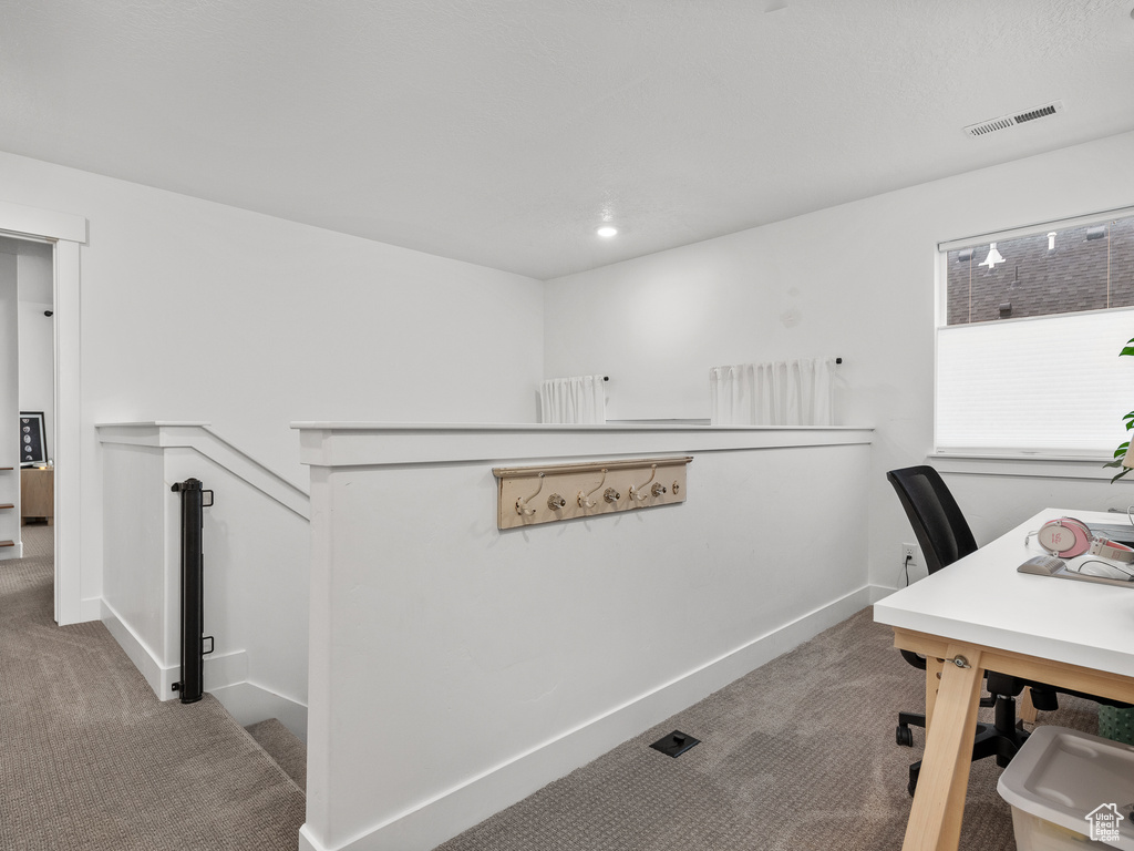 Carpeted office space featuring baseboards