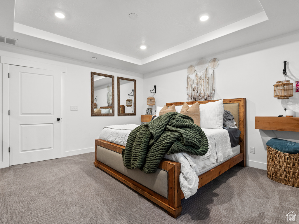 Bedroom featuring a raised ceiling, carpet flooring, and recessed lighting
