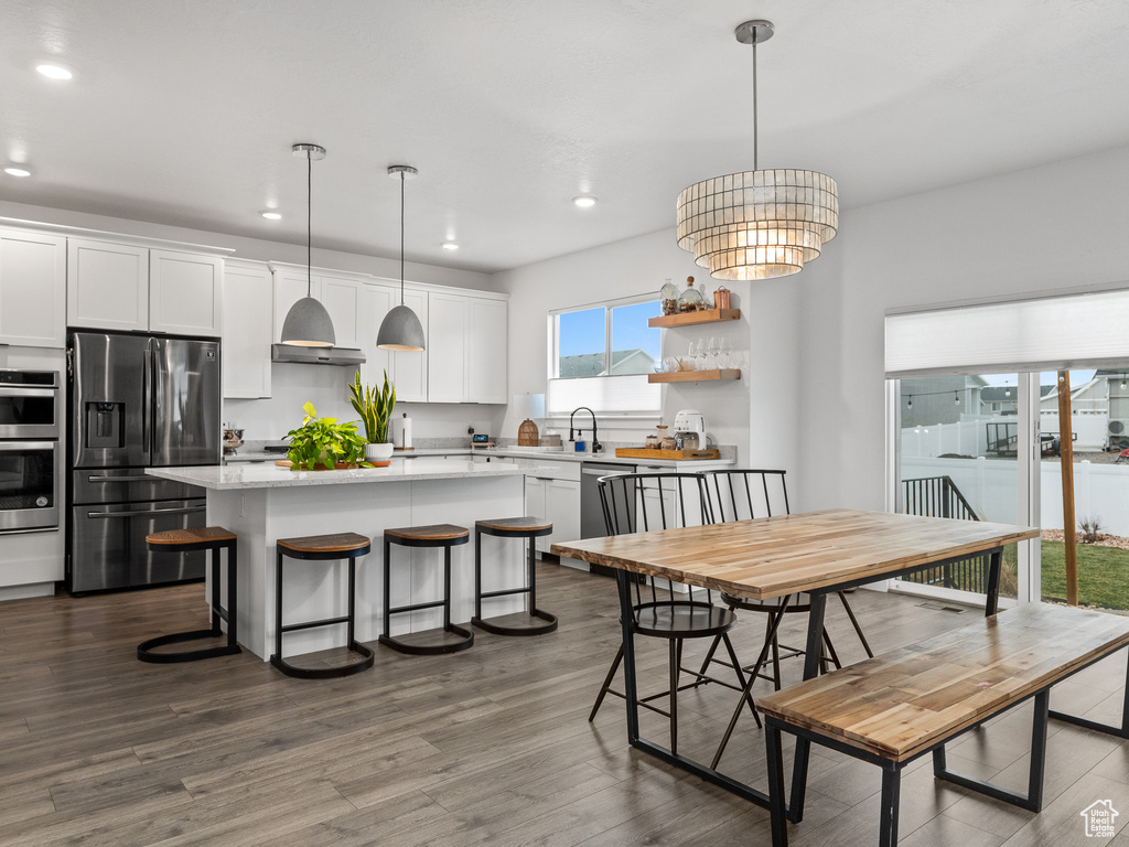 Dining space featuring recessed lighting, dark wood-style flooring, and a chandelier