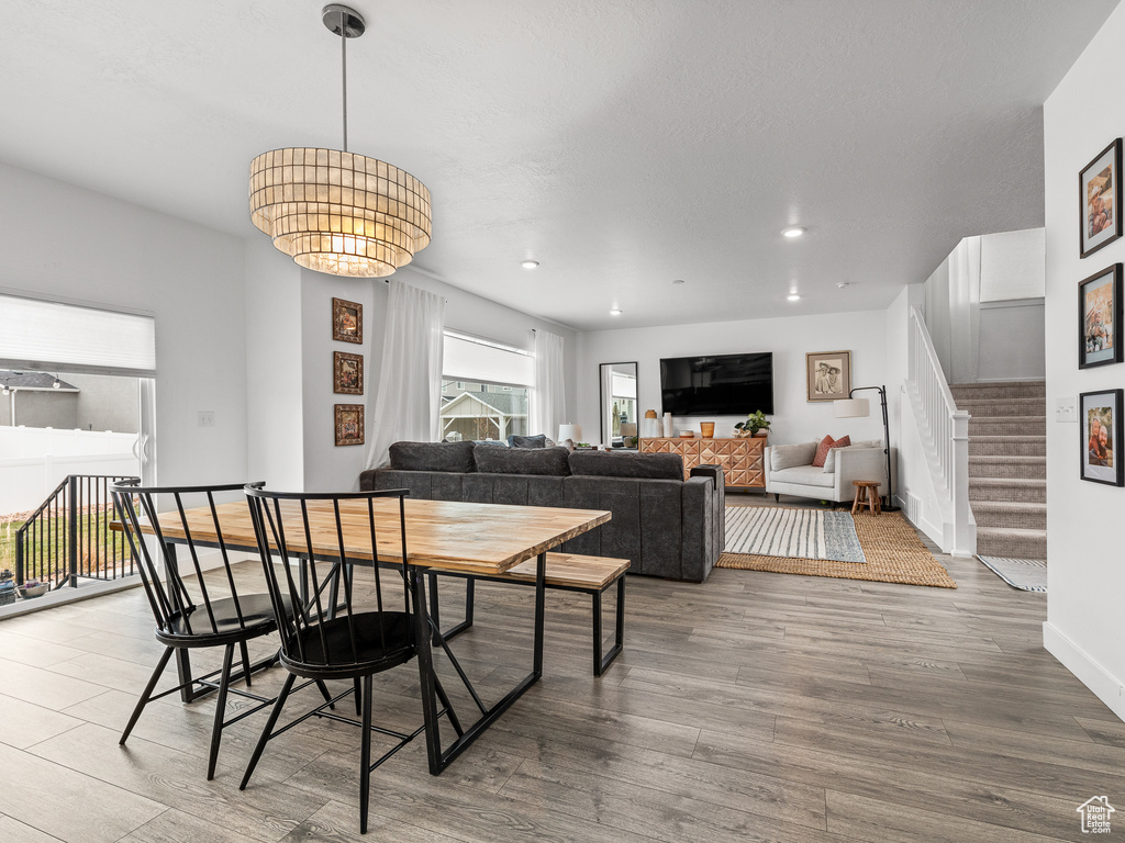 Dining space featuring wood finished floors, stairway, and recessed lighting