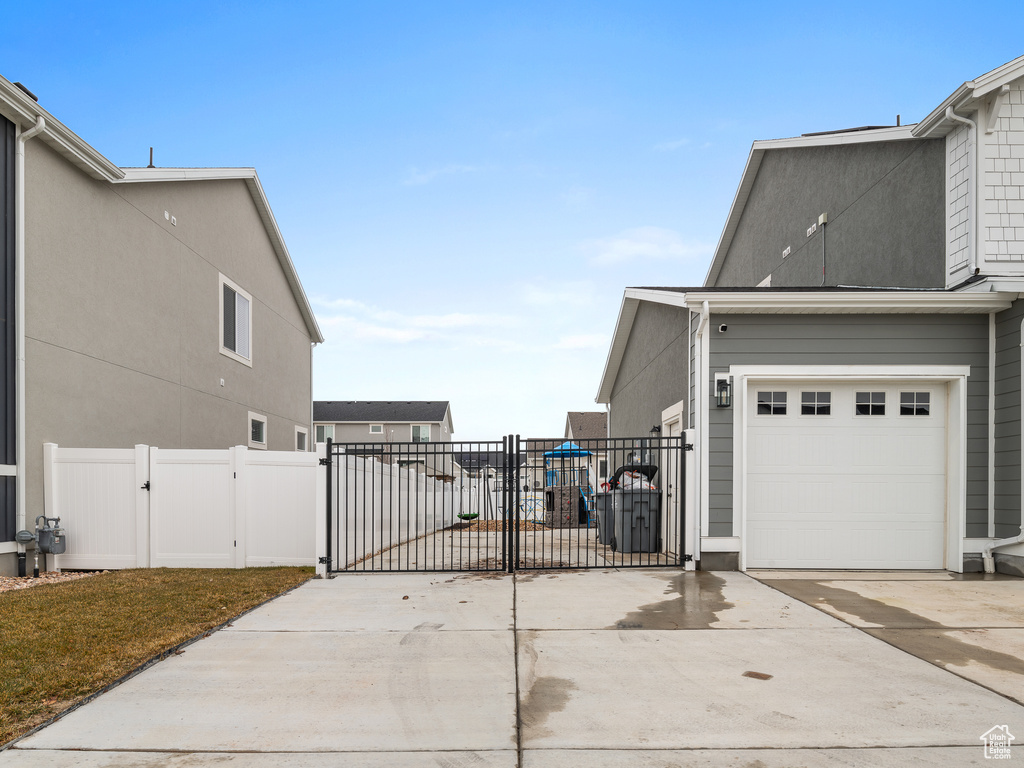 View of home's exterior featuring a gate, driveway, and a garage