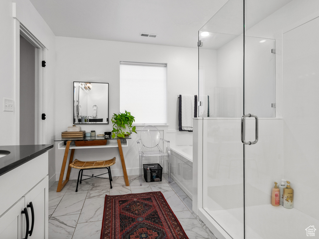 Bathroom featuring marble finish flooring, a garden tub, vanity, a stall shower, and recessed lighting