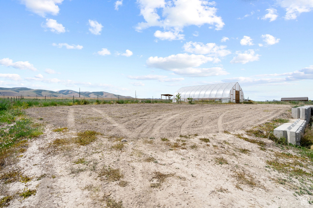 View of yard featuring an exterior structure, a rural view, an outbuilding, and a mountain view