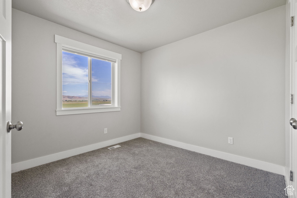 Empty room featuring carpet flooring and baseboards