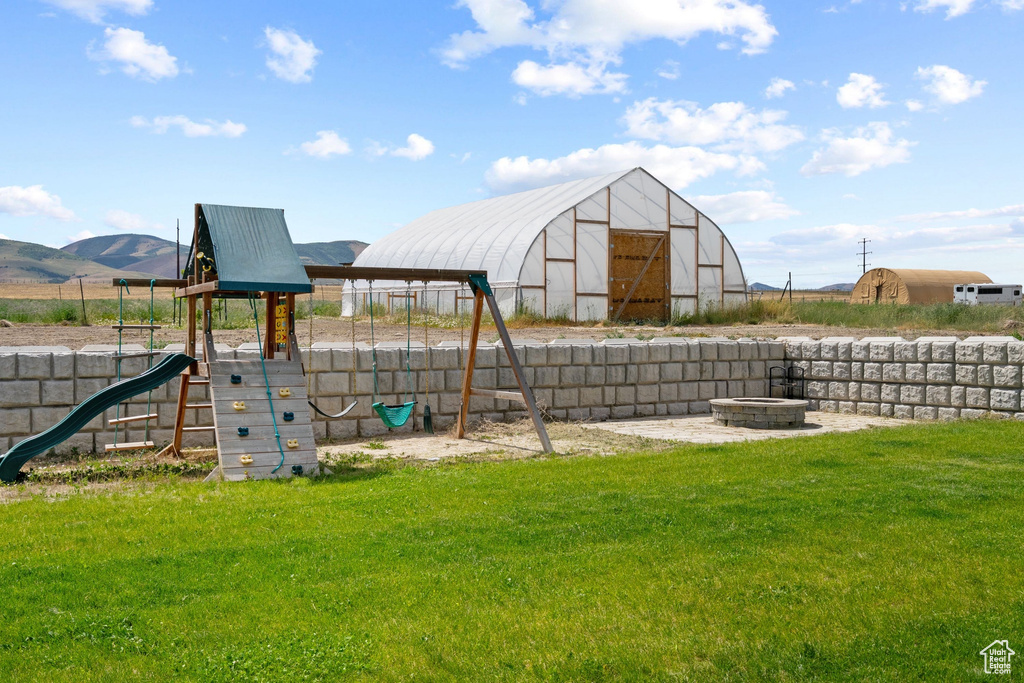 View of jungle gym with a lawn and a mountain view