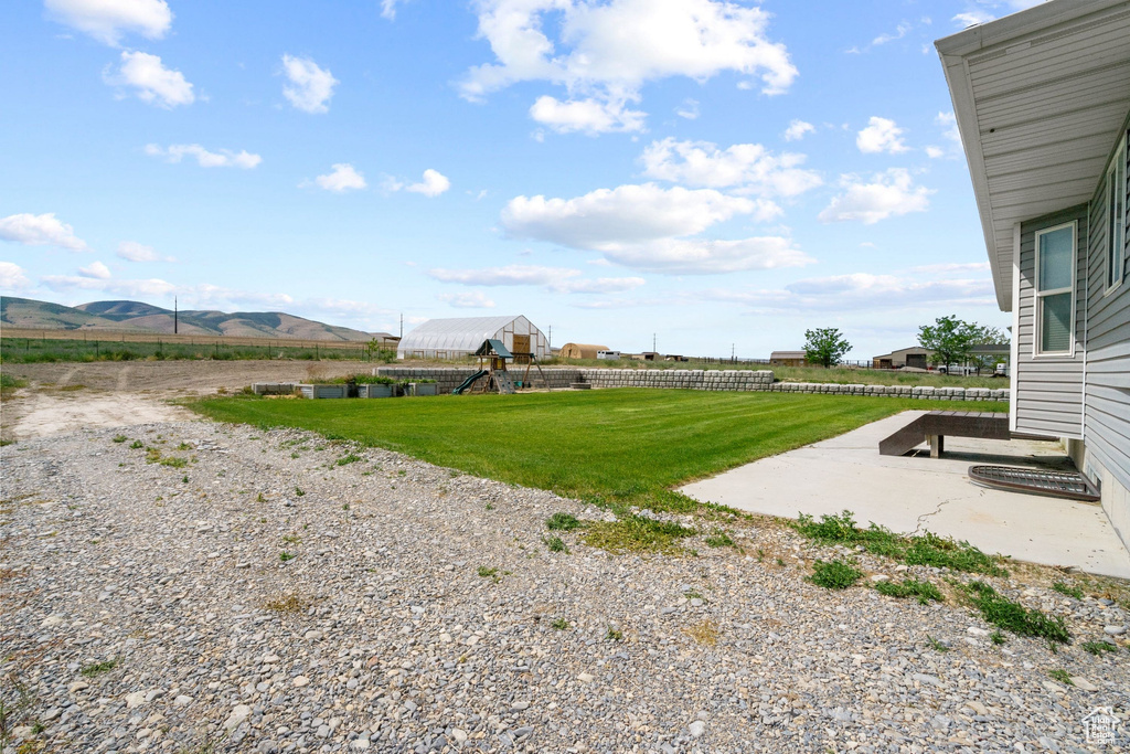 View of yard with a playground, a mountain view, and a patio