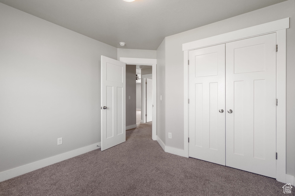 Unfurnished bedroom featuring carpet flooring and a closet