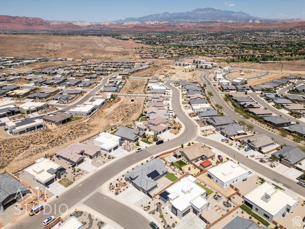 Aerial overview of property's location with a mountainous background and nearby suburban area