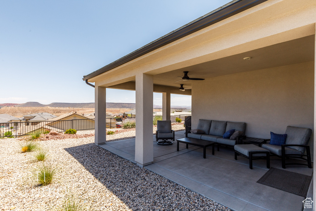 Fenced backyard with an outdoor hangout area, a patio area, ceiling fan, and a mountain view