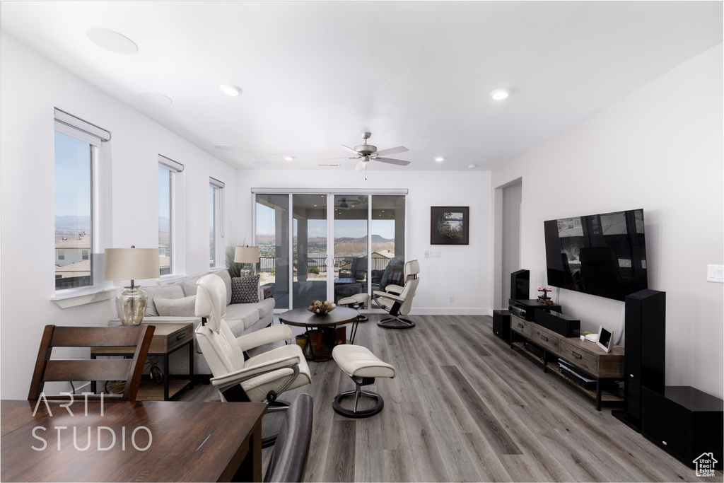 Living room with light wood-style floors, a ceiling fan, and recessed lighting
