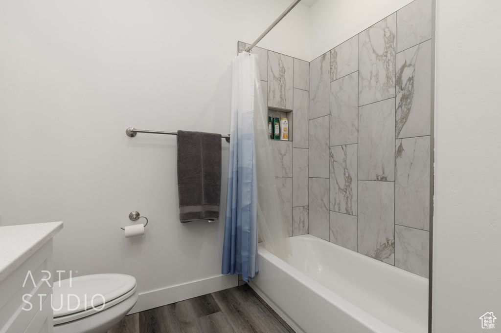 Bathroom featuring wood finished floors, shower / tub combo, and vanity