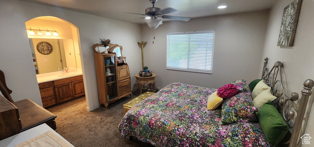 Carpeted bedroom featuring arched walkways, connected bathroom, a ceiling fan, and recessed lighting