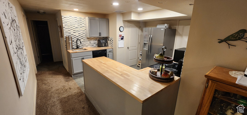 Kitchen with wooden counters, stainless steel fridge with ice dispenser, dishwasher, gray cabinets, and carpet floors